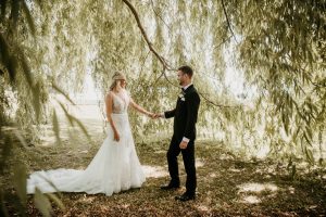 Wedding couple beneath a willow tree vineyard photoshoot at Aurora Cellars Winery, Lake Leelanau, MI