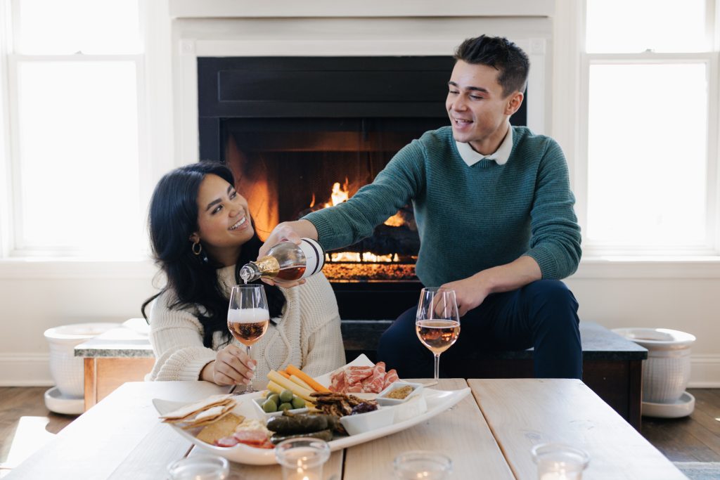 Couple enjoying Aurora Cellars wine at their Aurora's farmhouse in Lake Leelanau, MI